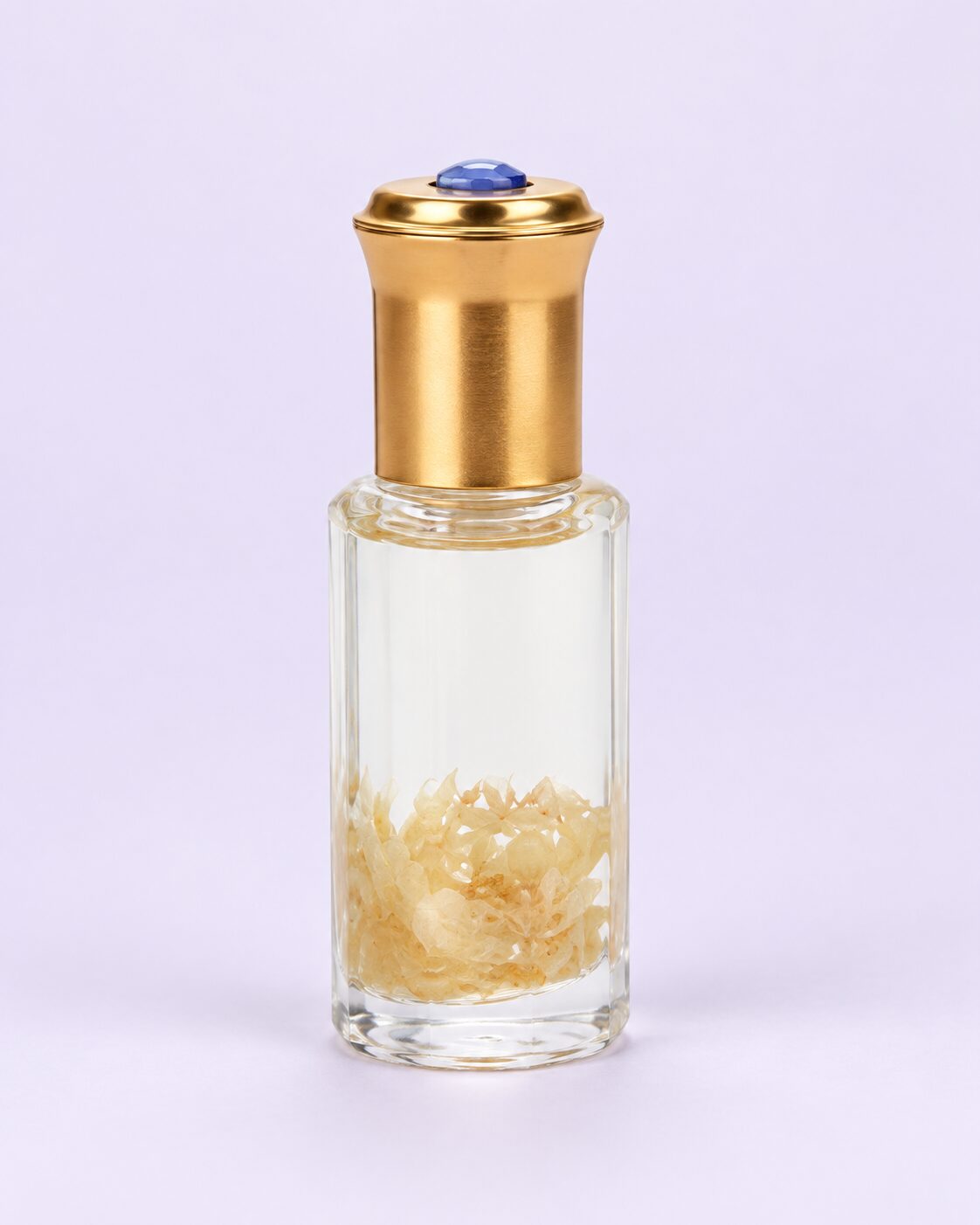 Dried flower cuticle oil in a clear cylindrical bottle with a gold cap